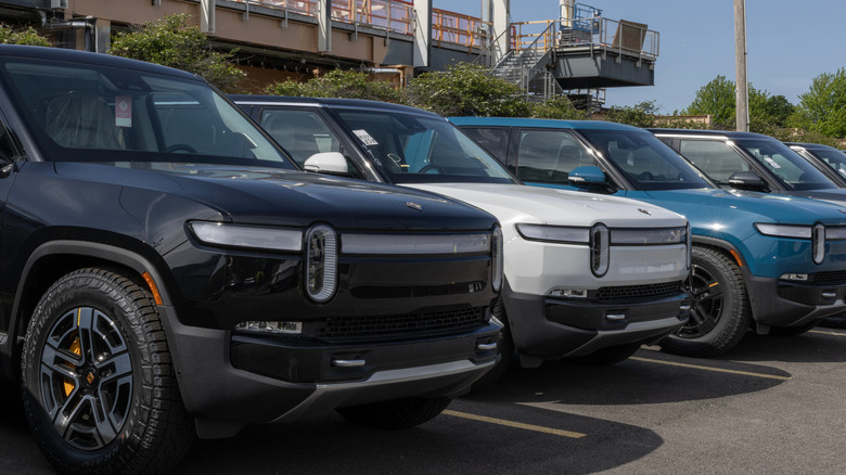 Rivian R1T trucks parked side-by-side in parking lot, front-right view