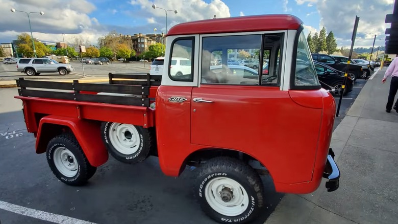 Red 1965 Jeep Forward Control Series parking in parking lot