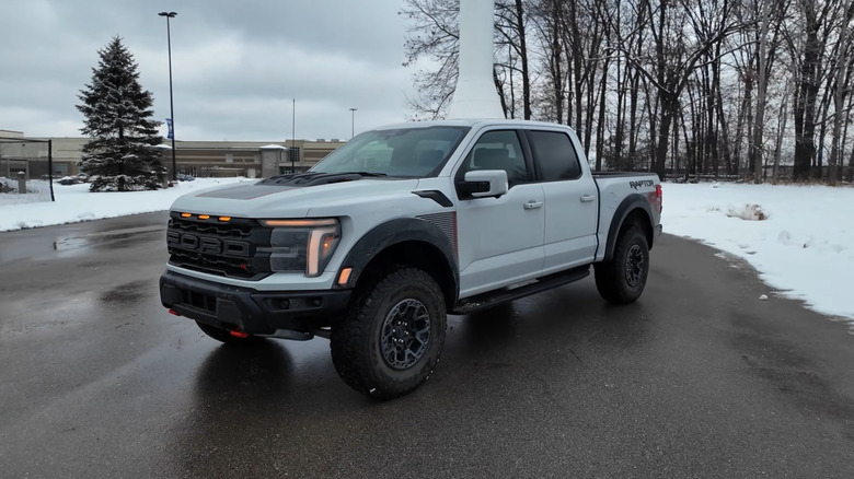 A white Ford F-150 Raptor R, front 3/4 view, snowy background