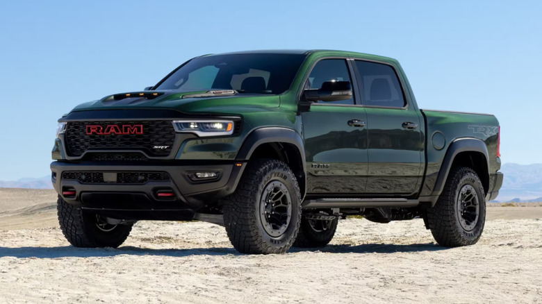 A green Ram 1500 TRX SRT sitting on sand, front 3/4 view