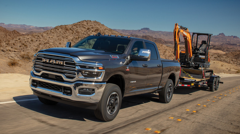 Gray Ram 2500 HD towing a mini excavator