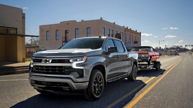A Chevrolet Silverado 1500 towing a vintage car
