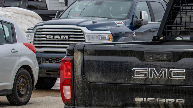 A rear-end shot of a GMC pickup and a front-end shot of a RAM pickup.