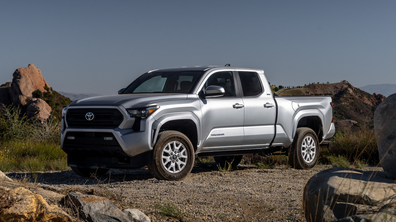Front 3/4 view of silver Toyota Tacoma parked in desert.