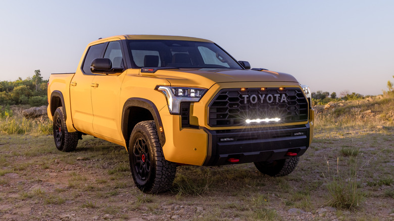 Front 3/4 view of yellow Toyota Tundra TRD Pro parked on trail.