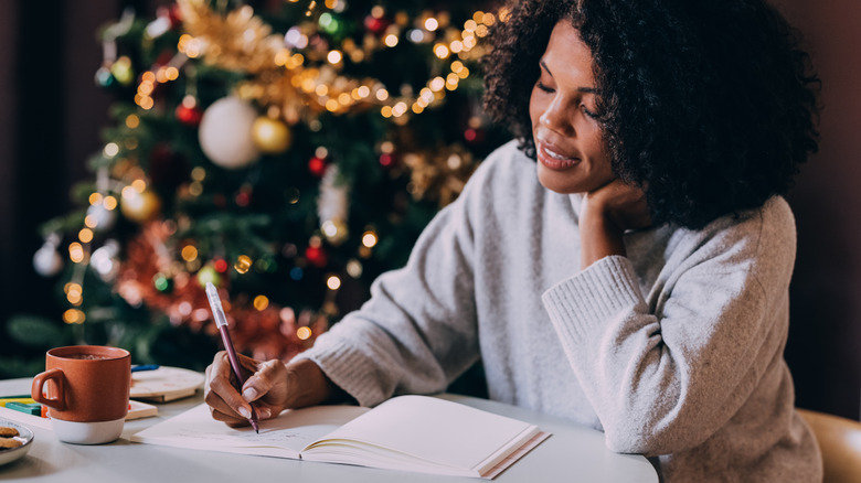 woman writing resolutions on notebook