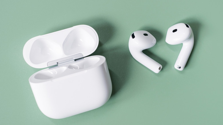 Apple AirPods 4 on a greeen background