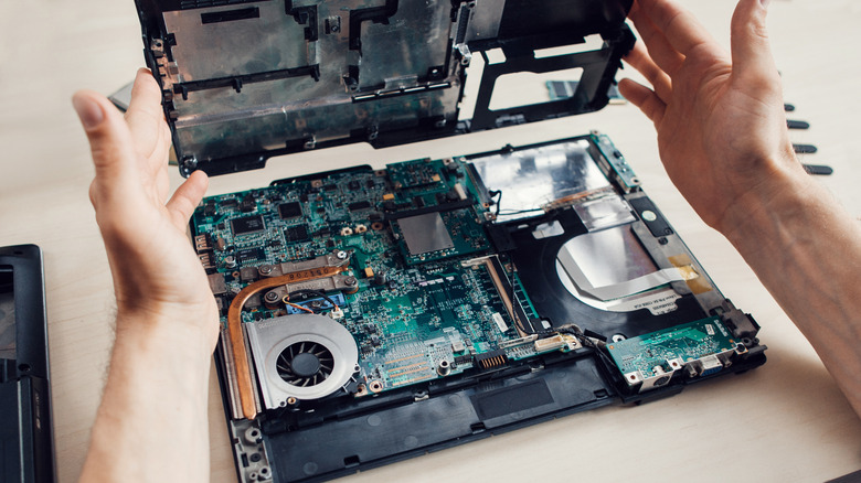 Person disassembling a laptop