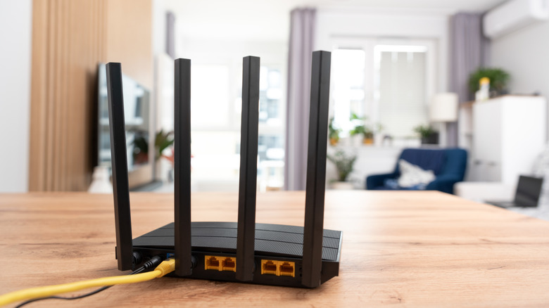 A Wi-Fi router with a house in the background.