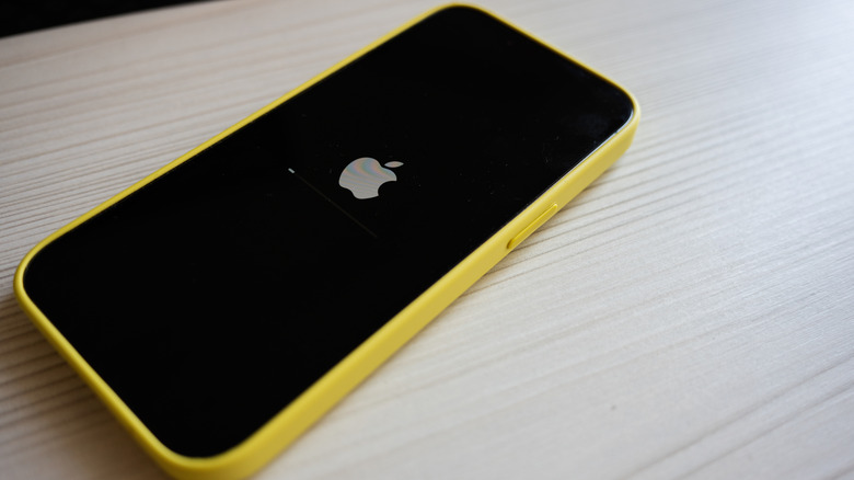 An iPhone restarting, the logo visible on the screen.