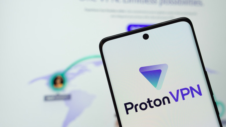 The ProtonVPN logo on a phone with ProtonVPN's website in the background.