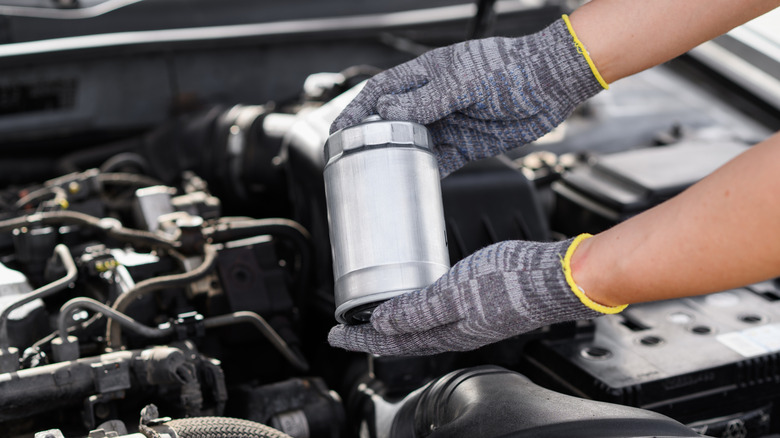 mechanic holding a fuel filter