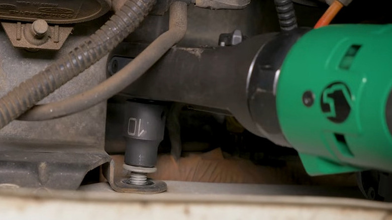 Green Matco ratchet installing a fastener.