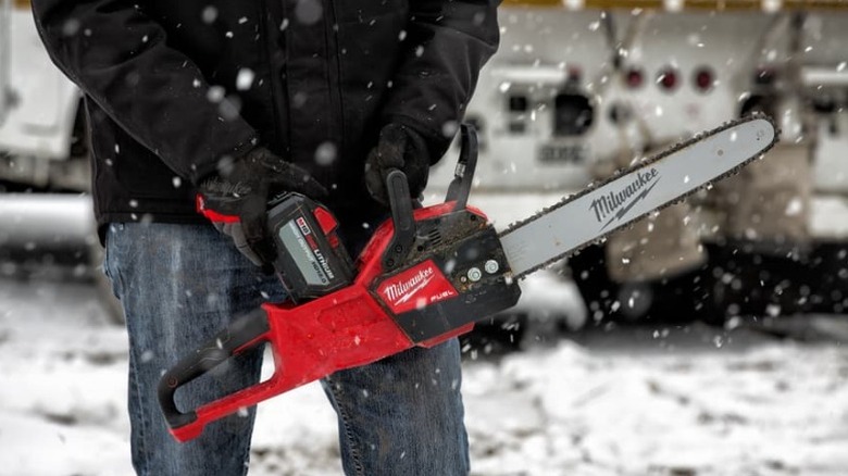 Person holding Milwaukee chainsaw