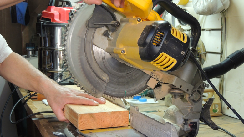 Person cutting 2x6 with miter saw