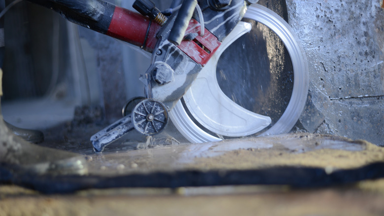 person using saw to cut concrete