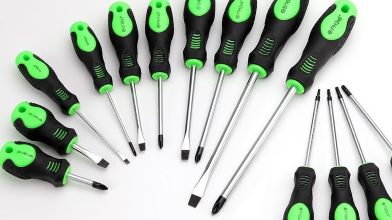 Black and green screwdrivers on a white surface.