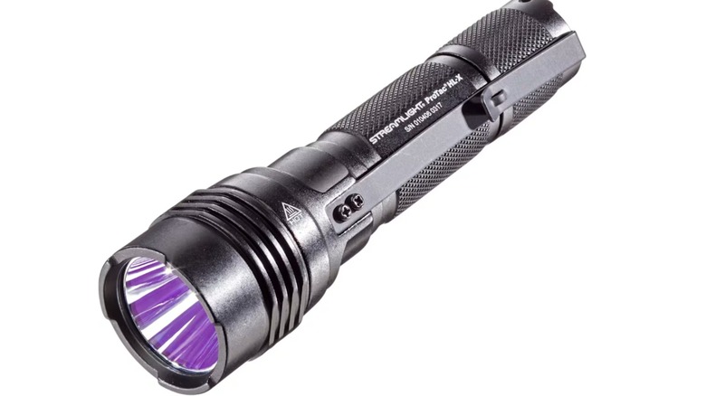 Black flashlight with clip against a white background