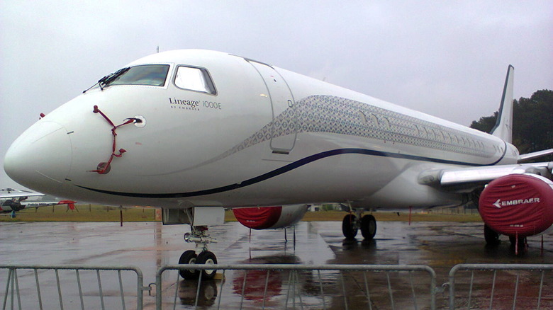 Embraer Lineage 1000E jet parked on the ground seen from front left