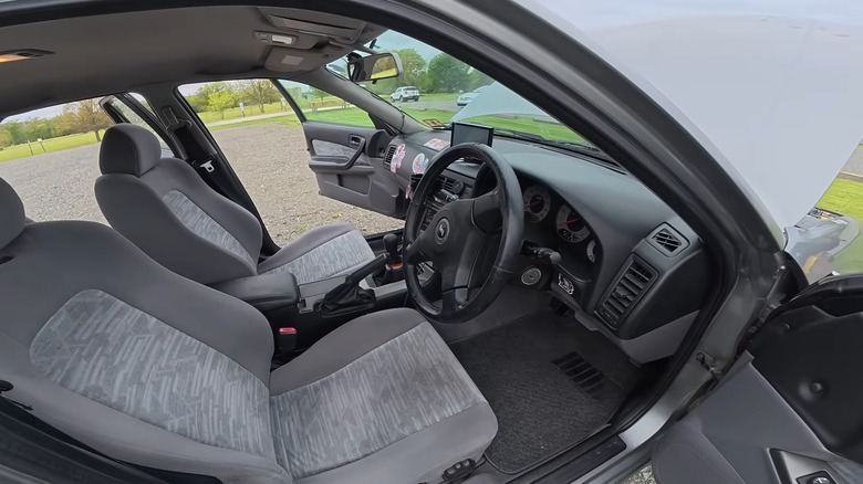Panoramic view of Nissan Skyline R34 sedan interior from driver's side door