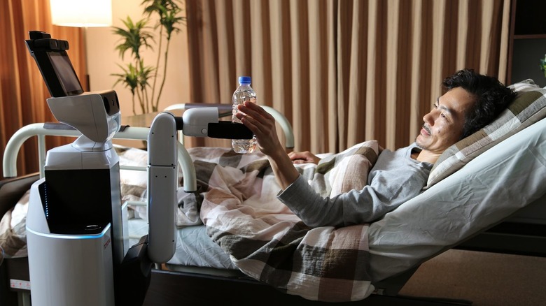 Toyota Home Support Robot (HSR) giving a water bottle to an elderly person