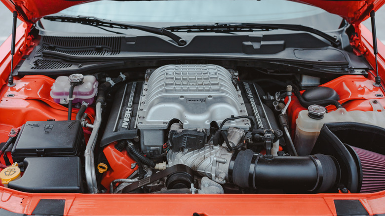 A close-up of an orange 6.2-liter Hellcat HEMI V8 engine bay.