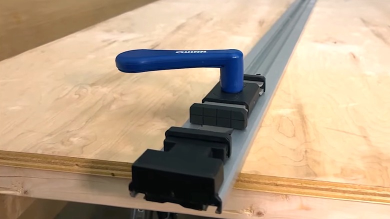 A Quinn clamp in place on a wooden cutting surface