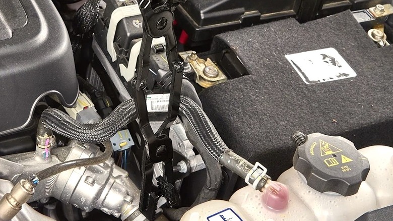 Quinn long-reach pliers being used to clamp an engine hose