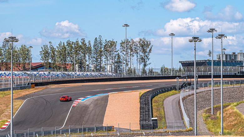 A single red racing car on a corner of the Igora Drive circuit