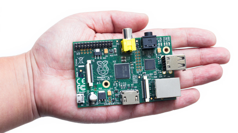 Hand holding Raspberry Pi on white background