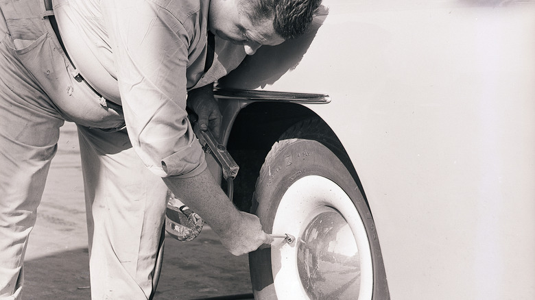 person inflating car tires