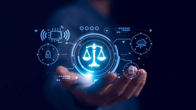 A blurred hand holds a computerized image of a justice scale and other smaller symbols