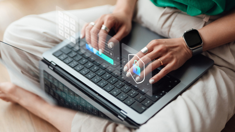 A person typing on a laptop with a hovering image of a padlock