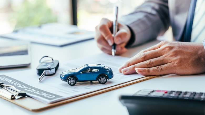 Signing papers at a car dealership