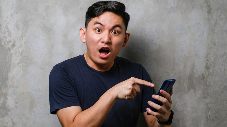 Young Asian man looking surprised