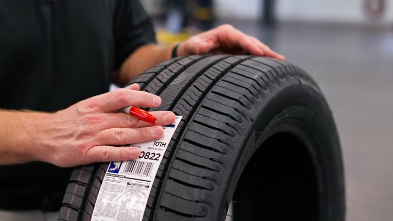Person with hands on a Michelin Defender 2 tire.
