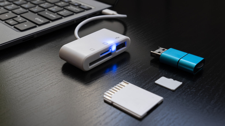 flash drive and memory cards in front of a USB hub connected to a laptop