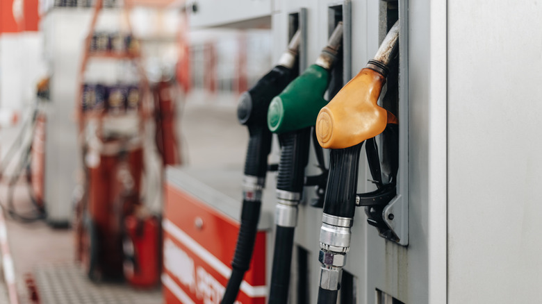 three different colored gas pumps