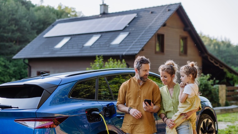 A family stands in front of property with solar panels