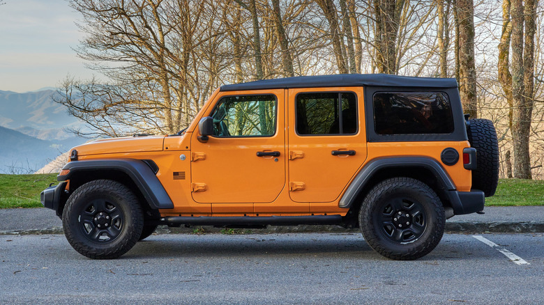 An orange Jeep Wrangler with a rear spare tire.