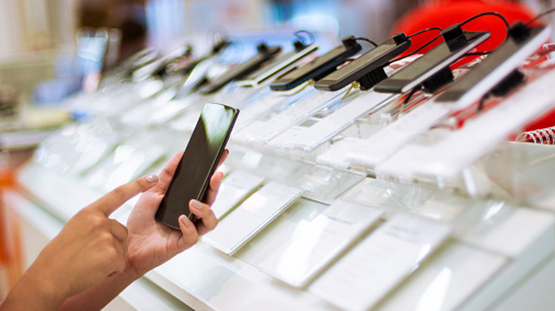 A person using a phone inside a store.