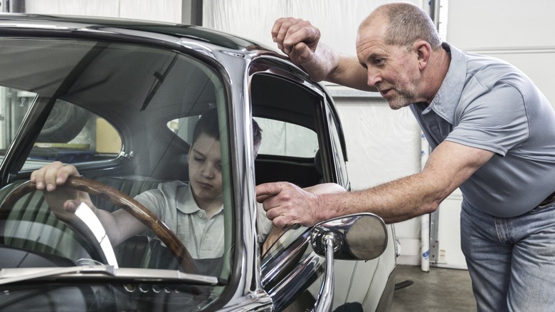 Man showing kid how to drive