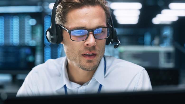 call center worker with glasses looking at screen