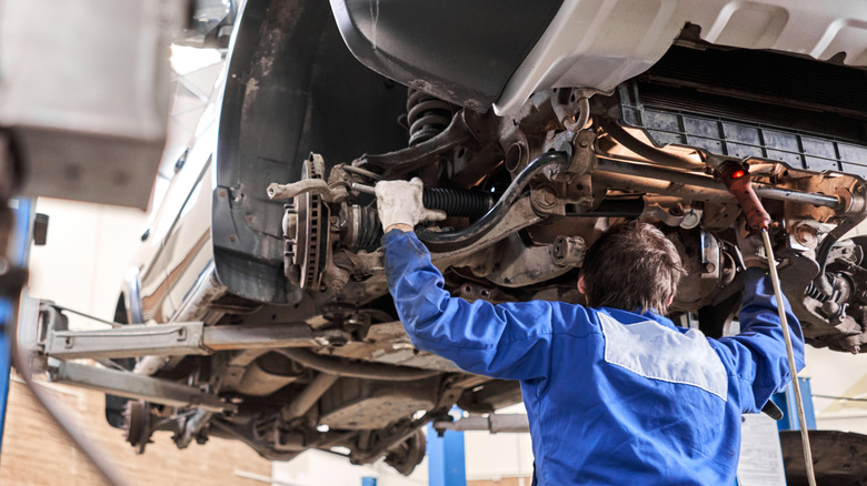 Mechanic working on car suspension