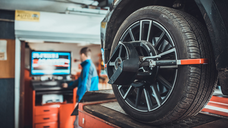 Wheel and tire being balanced by technician