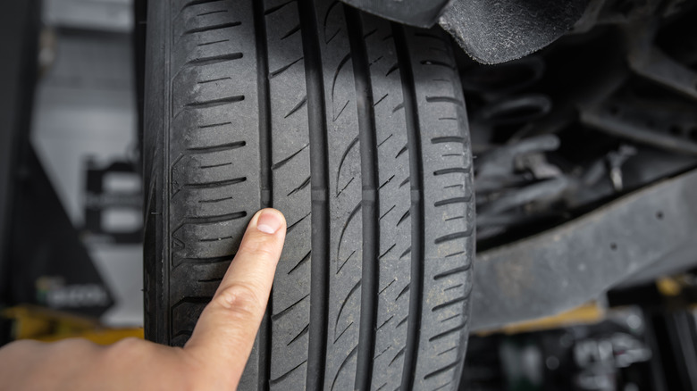 A mechanic pointing at tire tread