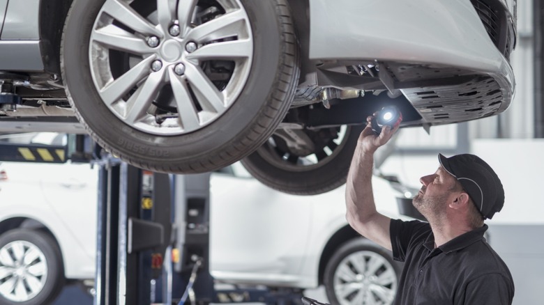 Mechanic at an auto shop inspecting a car