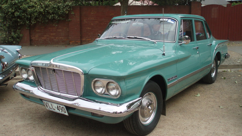 turquoise Plymouth Valiant in front of bricks