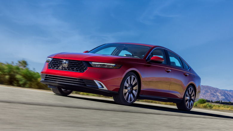 A 2023 Honda Accord in red on the move, front 3/4 view