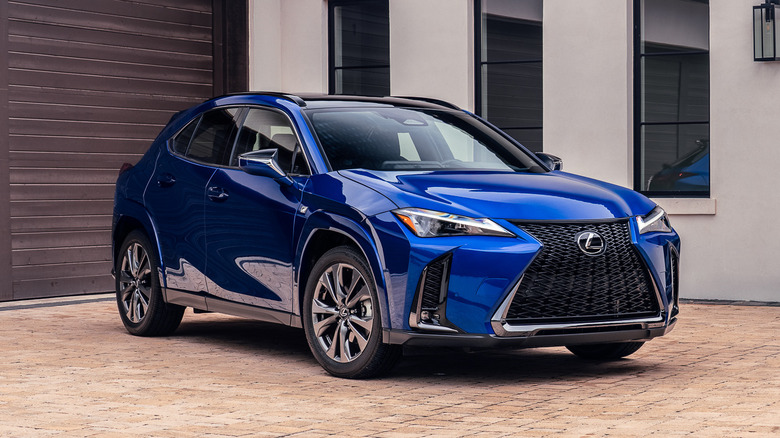 A 2026 blue Lexus UX 300h parked in front of a residential building.